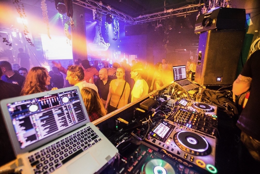 DJ decks facing a crowded dancefloor