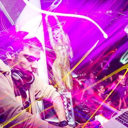 Jeff Kuzz performing under club lights with the dancefloor behind him
